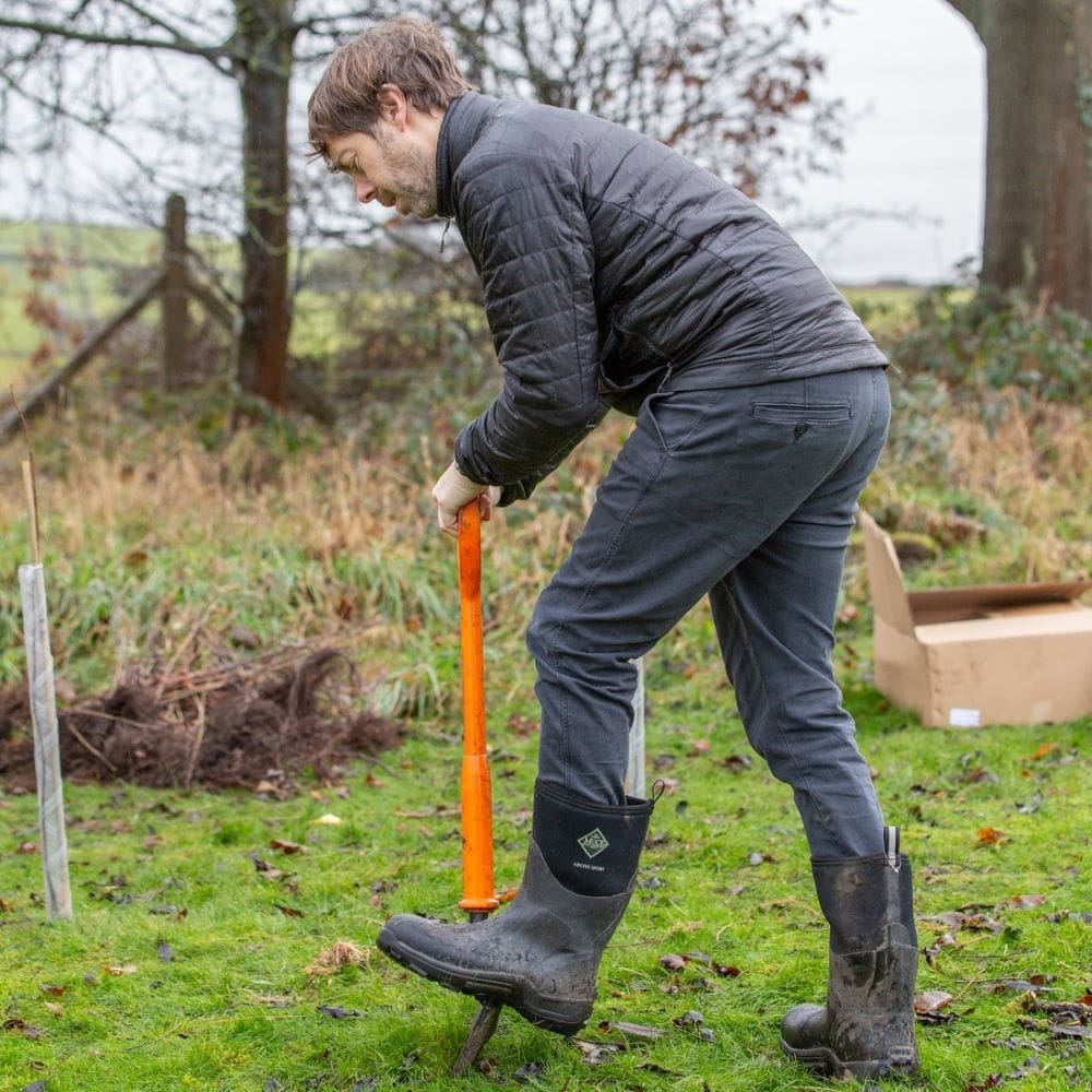 Councillor Scott Patient digging a hole, ready to plant a tree.