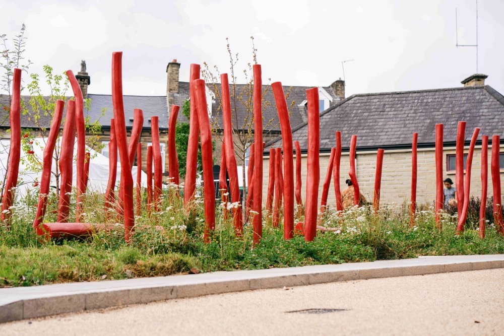 Red, wooden sculptural elements and natural in Elland make the space visually interesting and tactile.