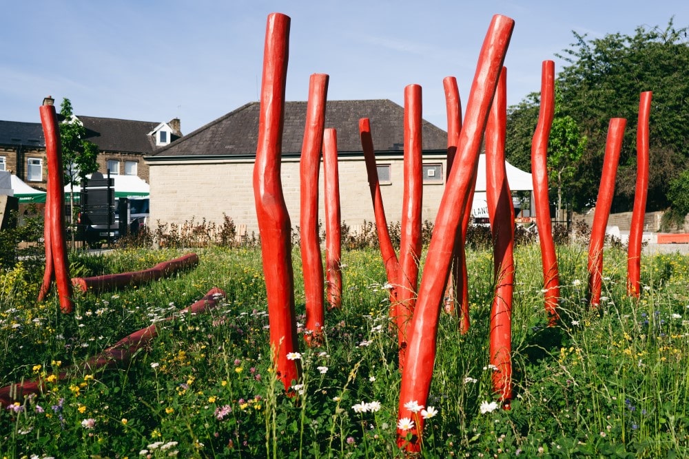 Red, wooden sculptural elements and natural in Elland make the space visually interesting and tactile.